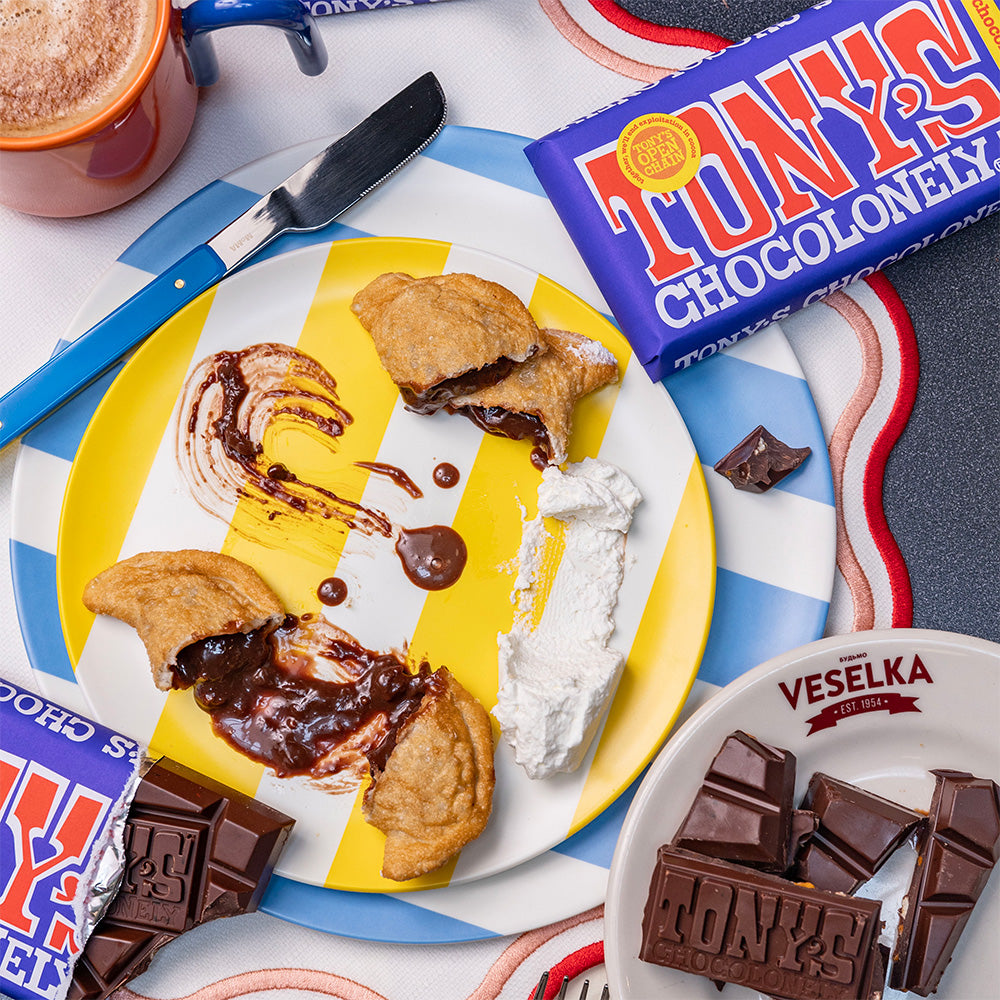 Multiple Chocolate Brownie pierogi cut open and oozing, pierogi are fried with tony's chocolate bars open and in full packaging scattered around