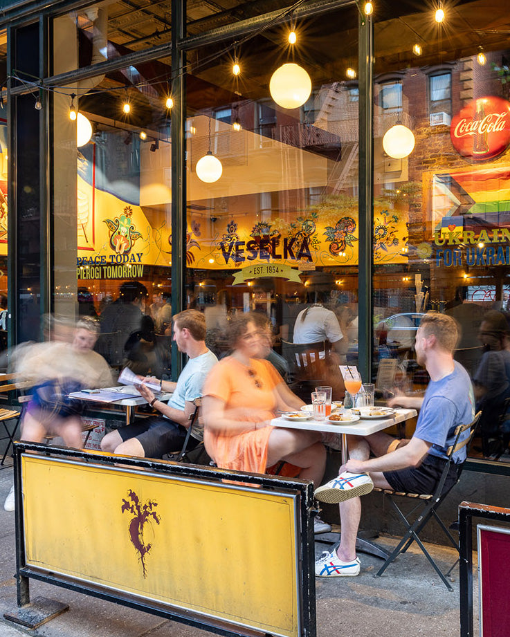 East Village Location in Summer, outdoor dining, with pride flag in background