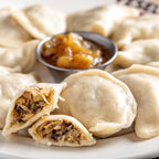 Sauerkraut and mushroom pierogi cut open, boiled on a plate 